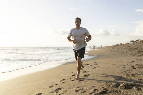 Young man jogging at beach - STF00017