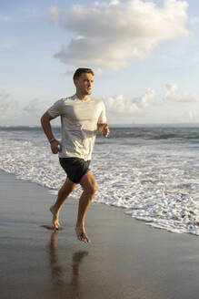 Man jogging near sea at beach - STF00020