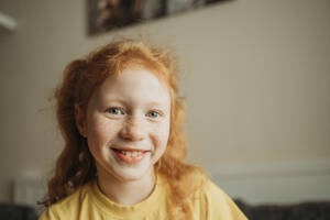 Smiling redhead girl with freckles on face at home - ANAF02564