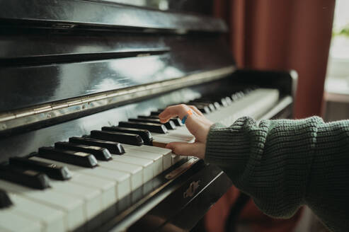 Hand of girl playing piano at home - ANAF02575