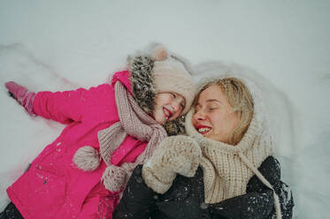 Happy mother enjoying with daughter on snow - ANAF02602