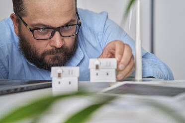 Architekt prüft Hausmodelle am Schreibtisch im Büro - AZF00585