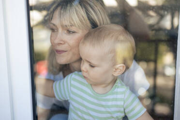 Mother and son behind glass window - JOSEF22403