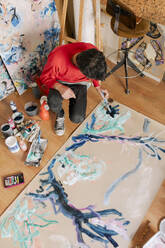 Reife Künstlerin malt mit Pinsel auf Leinwand im Kunstatelier - MMPF01094