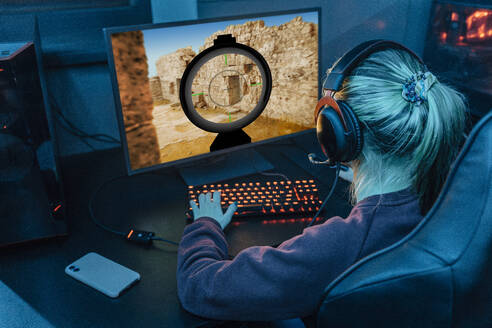 Gamer wearing headset and playing esports on desktop PC - EVKF00088