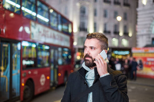 Junger gut aussehender Mann mit Smartphone in der Stadt London - HPIF35921