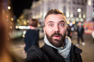 Junger hübscher Mann auf einem Spaziergang in der Londoner Innenstadt, der ein Selfie macht - HPIF35922