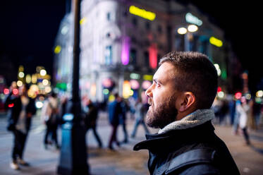 Young hipster man walking in the streets of London at night - HPIF35925