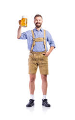 Handsome hipster young man in traditional bavarian clothes holding a mug of beer. Oktoberfest. Studio shot on white background, isolated. - HPIF35932