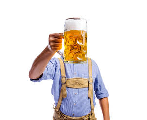Handsome young man in traditional bavarian clothes holding a mug of beer. Oktoberfest. Studio shot on white background, isolated. - HPIF35933