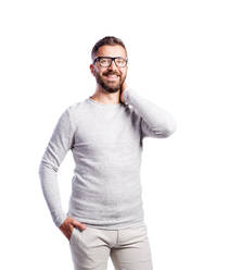 Junger gutaussehender Hipster-Mann in weißem langärmeligen T-Shirt, Hand in der Tasche, Studioaufnahme auf weißem Hintergrund, isoliert. - HPIF35952