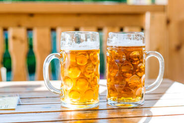 Zwei Bierkrüge auf dem Holztisch, sonniger Tag - HPIF35967