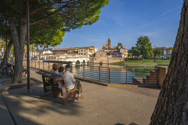 Einheimische betrachten die Ponte di Tiberio, die sich im Kanal von Rimini spiegelt, von Borgo San Giuliano, Rimini, Emilia-Romagna, Italien, Europa - RHPLF29966