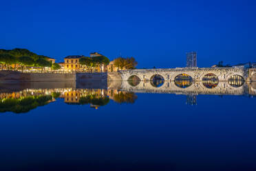 Blick auf die Ponte di Tiberio, die sich im Kanal von Rimini im Stadtteil Borgo San Giuliano in der Abenddämmerung spiegelt, Rimini, Emilia-Romagna, Italien, Europa - RHPLF30018