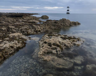 Felsen und Trwyn Du Leuchtturm in der Morgendämmerung, Penmon Point, Anglesey, Wales, Vereinigtes Königreich, Europa - RHPLF30172