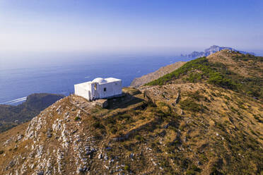 Luftaufnahme der weißen Kapelle von San Costanzo auf dem Gipfel eines Berges, der das Meer der Amalfiküste umgibt, Punta Campanella, Gemeinde Massa Lubrense, Provinz Neapel, Region Kampanien, Italien, Europa - RHPLF30281