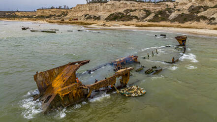 Männer zerlegen ein Boot am Strand von Shipwreck, Bucht von Santiago, Luanda, Angola, Afrika - RHPLF30546