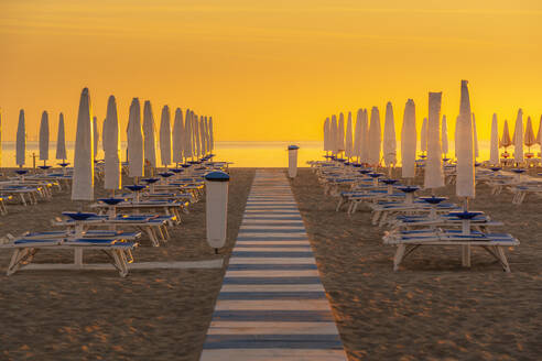 Blick auf Sonnenaufgang und Sonnenschirme am Lido am Strand von Rimini, Rimini, Emilia-Romagna, Italien, Europa - RHPLF31320