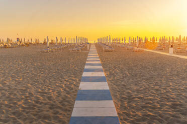 Blick auf Sonnenaufgang und Sonnenschirme am Lido am Strand von Rimini, Rimini, Emilia-Romagna, Italien, Europa - RHPLF31327