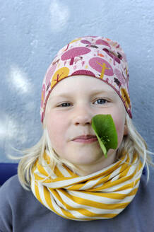 Portrait of little girl with leaf in mouth - GISF01010