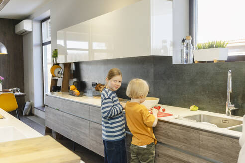 Mädchen und Junge bereiten Essen in der Küche zu Hause vor - SEAF02133