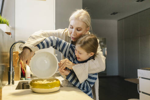 Großmutter und Enkelin gießen Spaghetti aus einem Sieb in eine Schüssel - SEAF02145