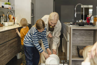 Familie wäscht gemeinsam Geschirr in der Küche zu Hause - SEAF02151