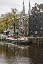 Tourboot in der Nähe von Gebäuden in der Stadt Amsterdam - JCCMF10992