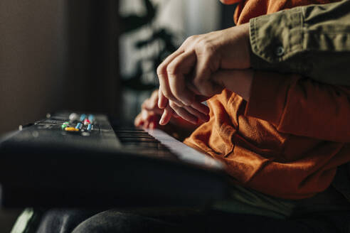 Vater bringt seinem Sohn zu Hause das Spielen auf dem E-Piano bei - VSNF01539