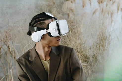 Junger Geschäftsmann trägt Virtual-Reality-Simulator im Garten - YTF01520