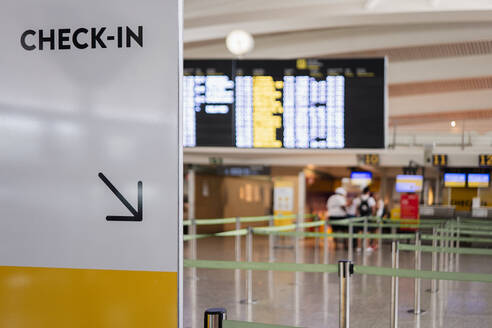 Check-in Text mit Pfeil-Symbol auf Plakat-Tafel in der Lobby des Flughafenterminals mit unscharfen Hintergrund - ADSF50541