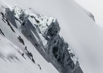 High angle view of unrecognizable skier skiing on snow covered mountain while enjoying winter vacation at Swiss Alps during sunny day - ADSF50572