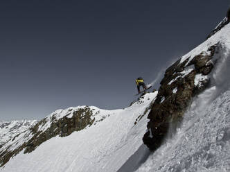 Von unten von unerkennbaren Skifahrer Reiten Skier auf Schnee bedeckten Berg beim Genießen Winterurlaub in den Schweizer Alpen auf sonnigen Tag - ADSF50599
