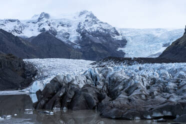 Ein komplizierter Mix aus Eis- und Felsformationen umrahmt eine ruhige Gletscherlagune im Vatnajokull-Nationalpark in Island. - ADSF50639