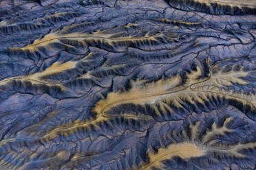 An aerial perspective showcases intricate patterns of blue ridges and valleys within a vast desert terrain, highlighting nature's artistry. - ADSF50649