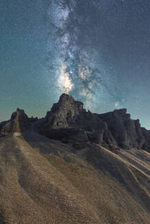 Die prächtige Milchstraße erhebt sich über einer zerklüfteten Felslandschaft, wobei der intensive Kern der Galaxie einen himmlischen Schein auf die nächtliche Landschaft wirft - ADSF50660