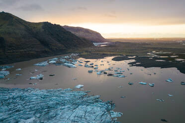 Ein fesselnder Blick auf einen Gletscher, der sich in den ruhigen Gewässern des Vatnajokull-Nationalparks spiegelt, unter einem sanft beleuchteten Himmel. - ADSF50679