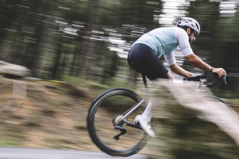 Action-Shot eines Radfahrers in Bewegungsunschärfe beim Bergabfahren auf einem Waldweg - ADSF50718