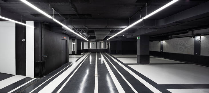 Beleuchtete, leere, geräumige Lobby mit schwarzer Decke und Säulen und Marmorfußboden in einer stilvollen Luxus-Penthouse-Wohnung - ADSF50764