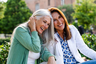 Schöne ältere Frauen, die sich in der Stadt im Freien treffen - Attraktive, fröhliche, reife Freundinnen, die Spaß haben, einkaufen gehen und sich austauschen, Konzepte für den älteren Lebensstil - DMDF07753