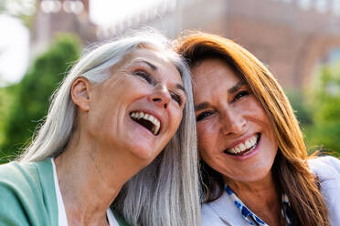 Schöne ältere Frauen, die sich in der Stadt im Freien treffen - Attraktive, fröhliche, reife Freundinnen, die Spaß haben, einkaufen gehen und sich austauschen, Konzepte für den älteren Lebensstil - DMDF07760