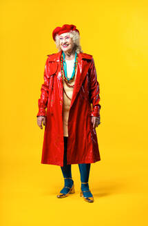 Beautiful senior old woman wearing fancy party clothes acting on a colored background in studio - Conceptual image about third age and seniority, old people feeling young inside. - DMDF07831