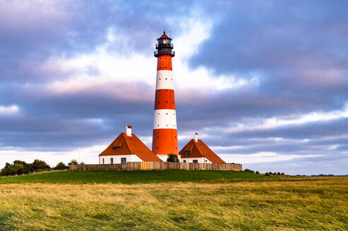 Deutschland, Schleswig-Holstein, Westerhever, Wolken über dem Leuchtturm Westerheversand in der Abenddämmerung - EGBF00967