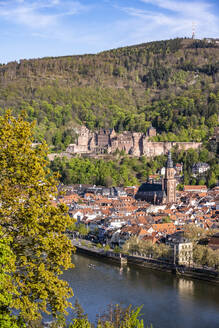 Germany, Baden-Wurttemberg, Heidelberg, Old town buildings with Neckar river in foreground and Heidelberg Castle in background - EGBF00987