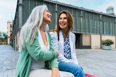 Schöne ältere Frauen, die sich in der Stadt im Freien treffen - Attraktive, fröhliche, reife Freundinnen, die Spaß haben, einkaufen gehen und sich austauschen, Konzepte für den älteren Lebensstil - DMDF07936