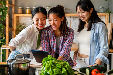 Glücklich schöne chinesische Frauen Freunde Bonding zu Hause und kochen köstliche Mahlzeit zusammen- Playful hübsche asiatische weibliche Erwachsene treffen und Spaß haben zu Hause, Konzepte über Lifestyle, häusliches Leben und Freundschaft - DMDF07965