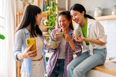 Happy beautiful chinese women friends bonding at home - Playful pretty asian female adults meeting and having fun at home, concepts about lifestyle, domestic life and friendship - DMDF07980