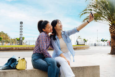 Happy beautiful chinese women friends bonding outdoors in the city - Playful pretty asian female adults meeting and having fun outside, concepts about lifestyle and friendship - DMDF08000