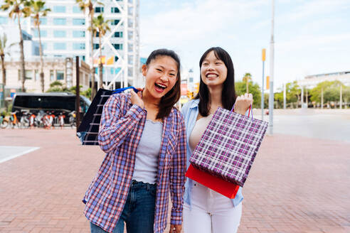 Happy beautiful chinese women friends bonding outdoors in the city - Playful pretty asian female adults meeting and having fun outside, concepts about lifestyle and friendship - DMDF08002