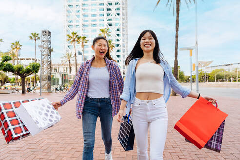 Happy beautiful chinese women friends bonding outdoors in the city - Playful pretty asian female adults meeting and having fun outside, concepts about lifestyle and friendship - DMDF08004